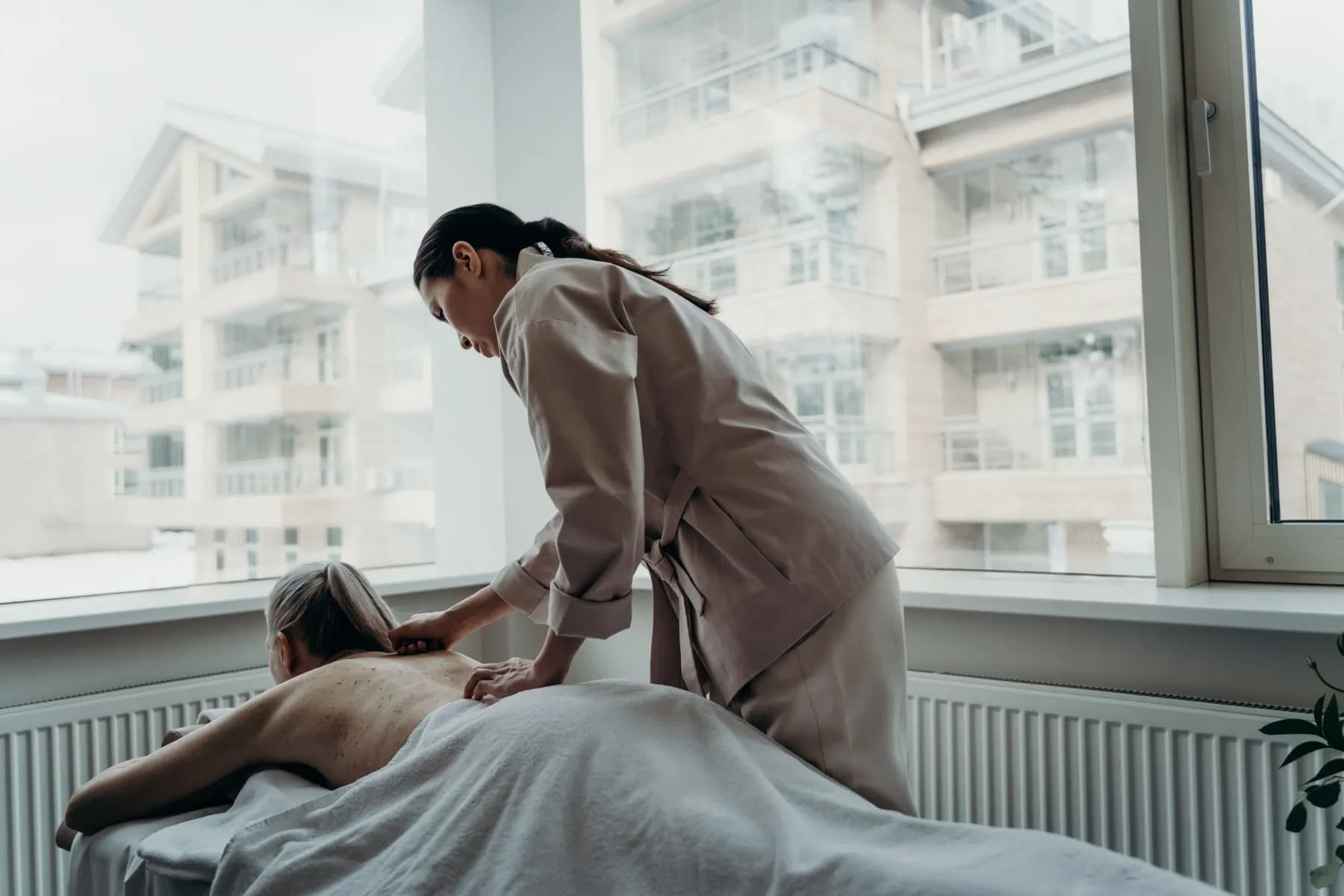A massage therapist at work in a bright city studio
